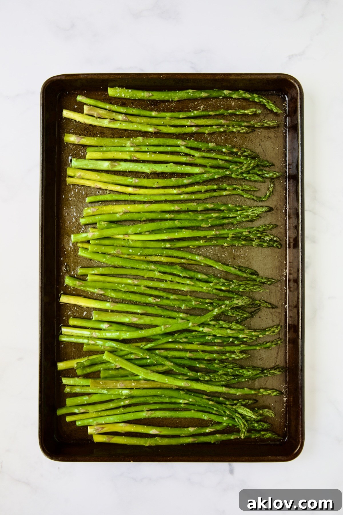 Perfectly roasted asparagus spears on a rimmed baking sheet, showcasing their tender-crisp texture.
