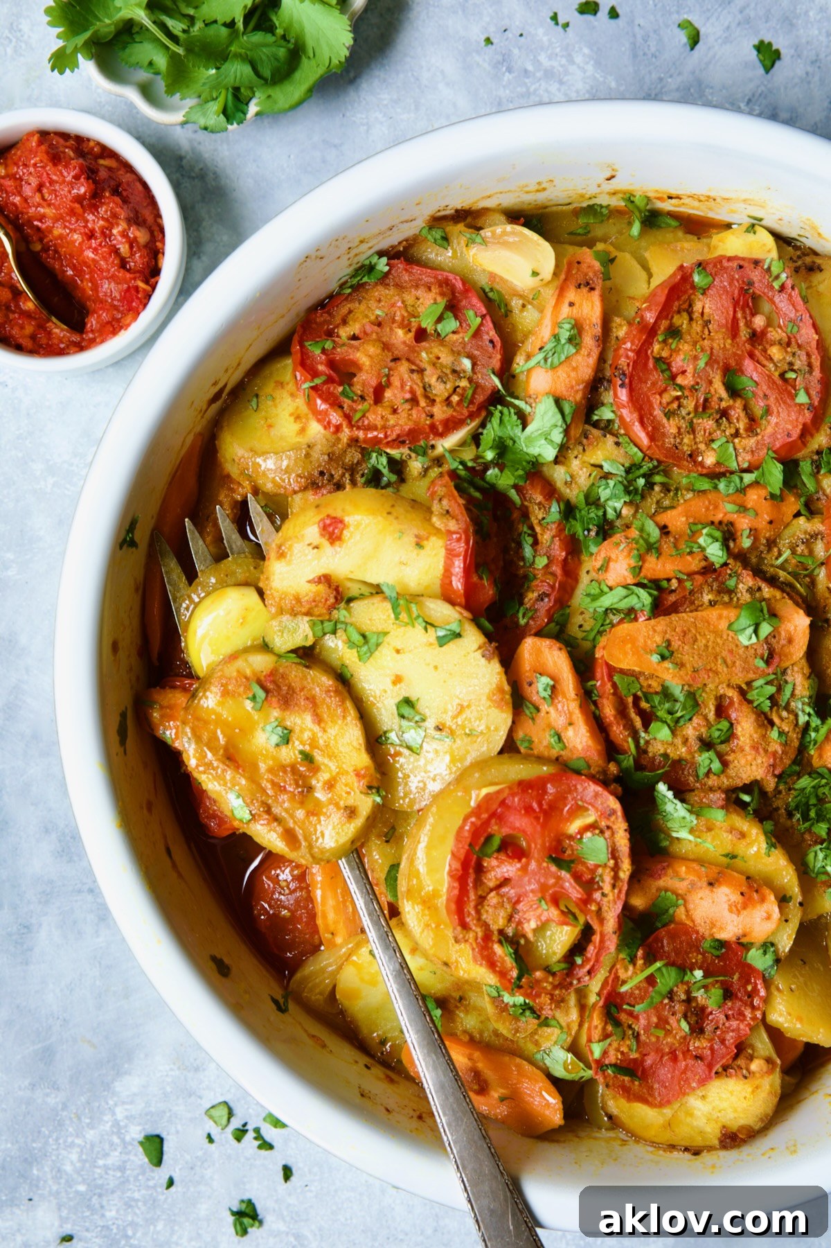 Moroccan Potato Tagine in round white baking dish with serving fork.