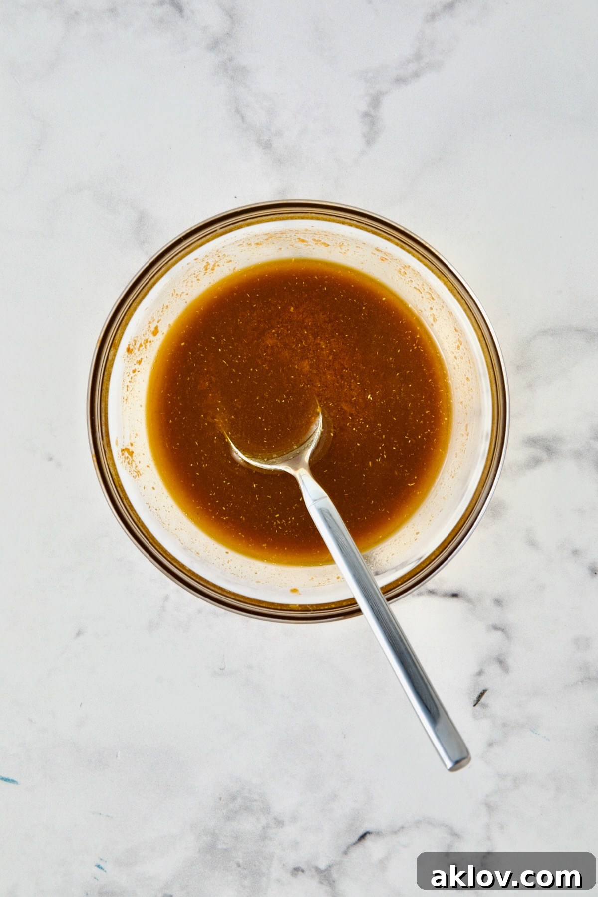 Olive oil and spices blended together in glass bowl.
