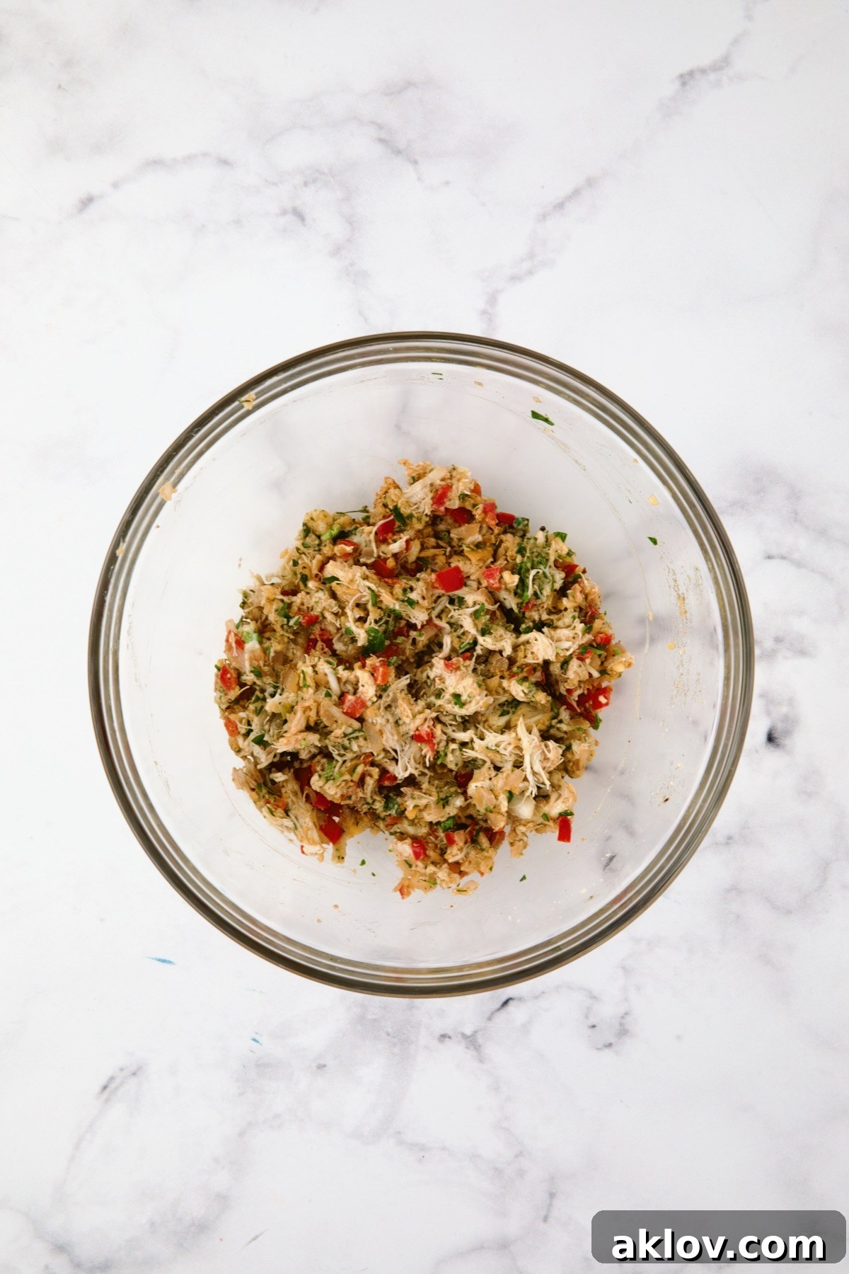 All ingredients for the crab filling mixed together in a glass bowl, ready for stuffing.