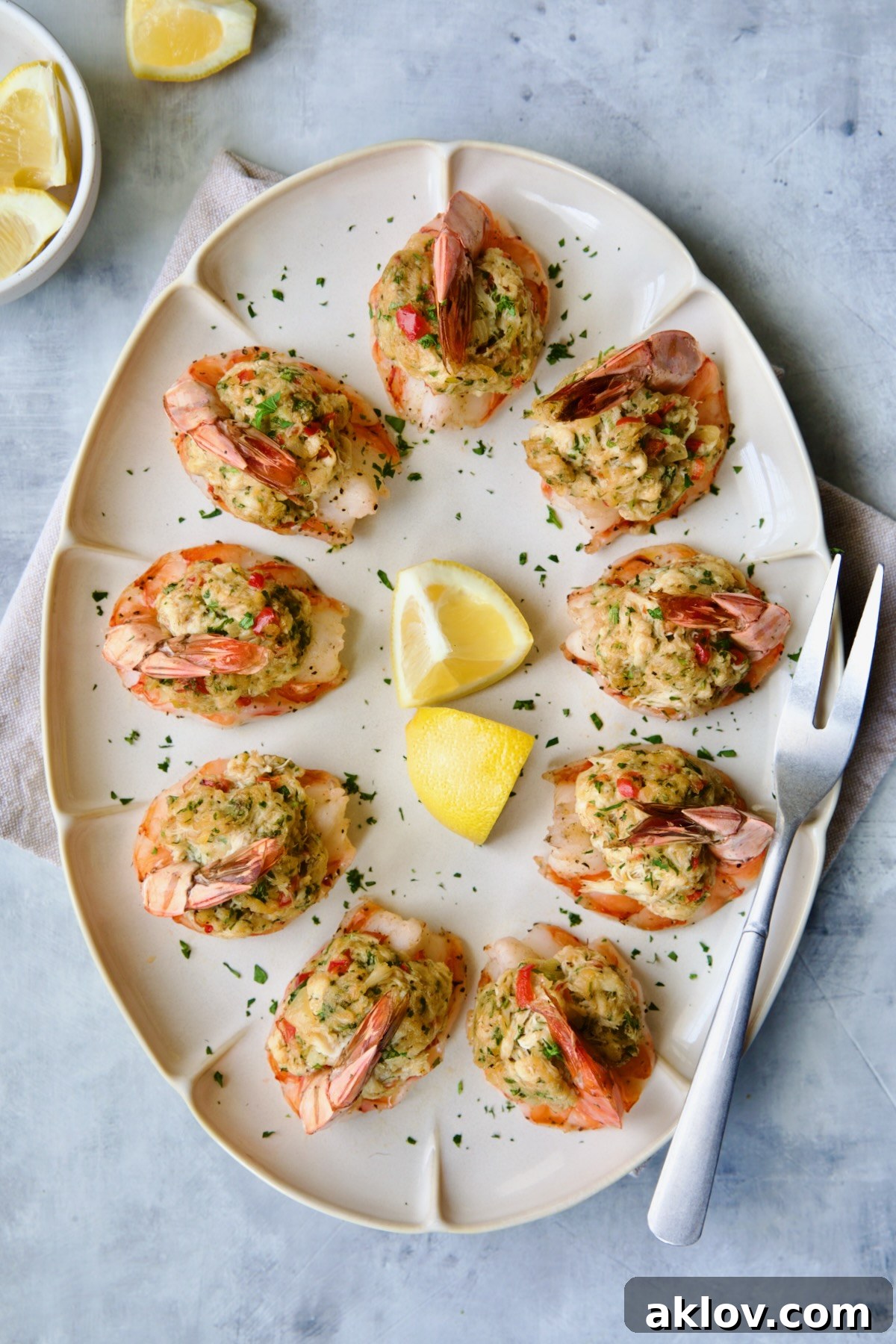 Crab-Stuffed Shrimp beautifully presented on an oval white platter, garnished with fresh parsley and bright lemon wedges.