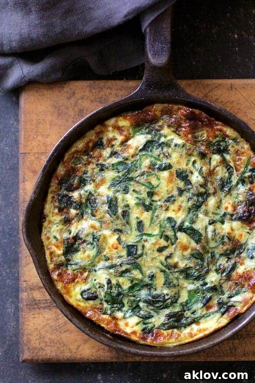 Photo of Spinach Leek and Feta Cheese Frittata fresh from the oven in cast iron skillet on wood trivet. A truly delectable dish perfect for any meal.