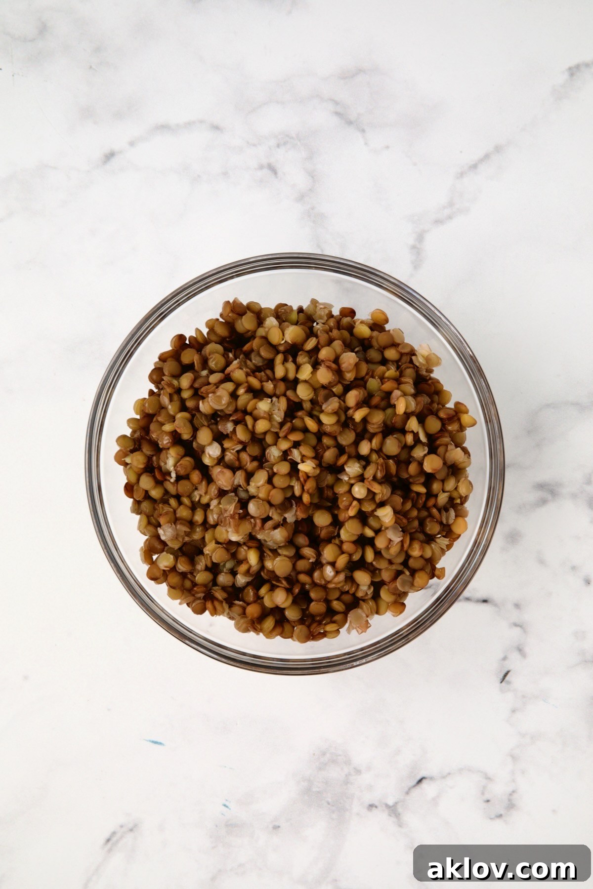 Perfectly cooked brown lentils, tender and intact, in a glass bowl, ready to be added to the Lemony Lentil Salad.