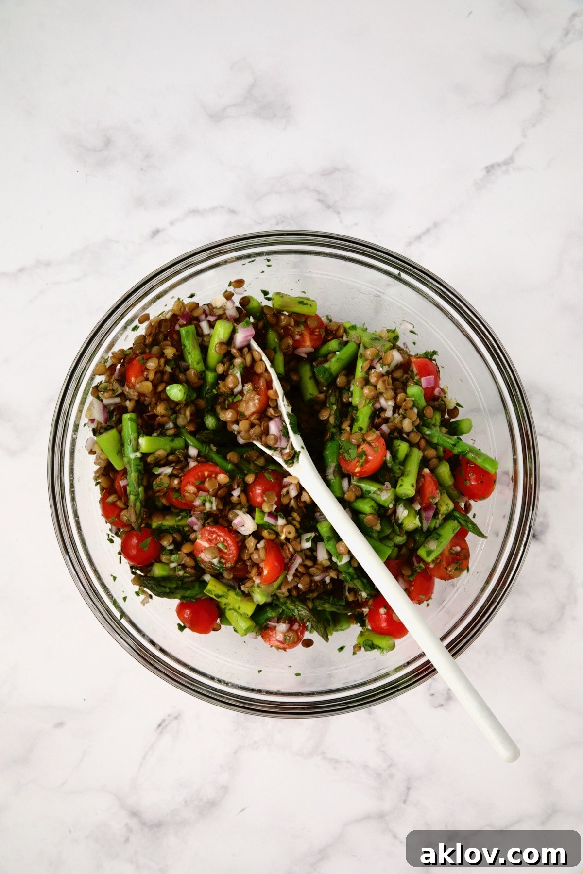 The Lemony Lentil Salad base, fully combined and glistening with the fresh lemon vinaigrette, in a large glass bowl, ready for the final touch of feta.