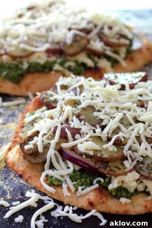 Naan Potato Pizza assembled with radish pesto, smoked mozzarella, red onion, and roasted potatoes, before baking.