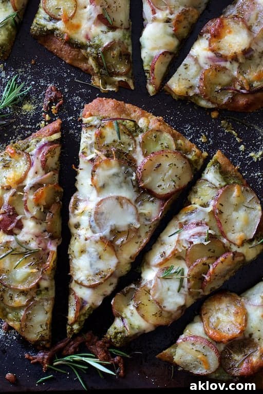 Close-up view of sliced Naan Potato Pizza, showing layers of creamy potatoes, pesto, and melted smoked mozzarella.