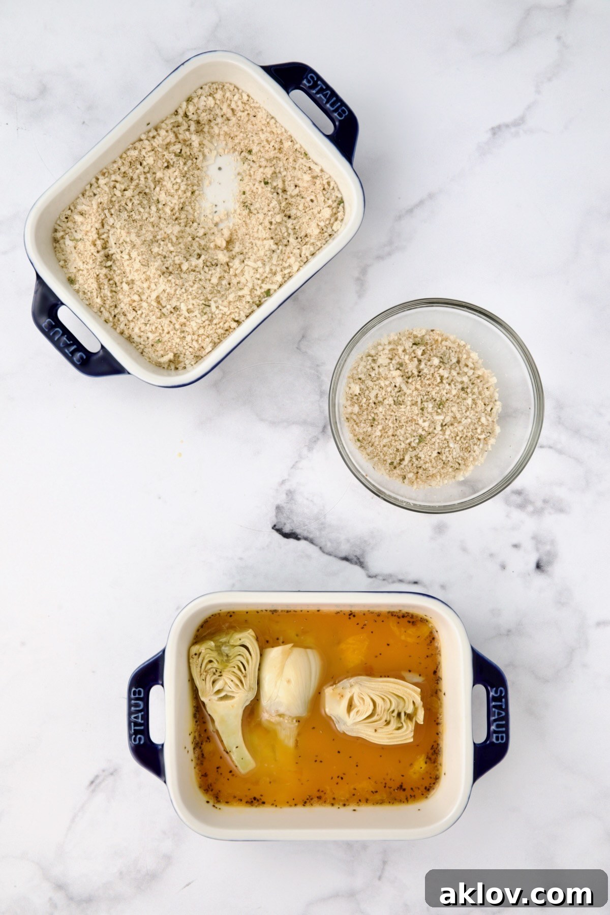 Three containers with breadcrumbs in two, and eggs in a third.