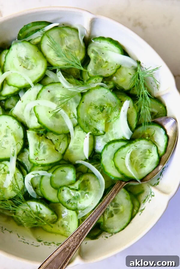 Cucumber Onion Salad in serving bowl with serving spoon.