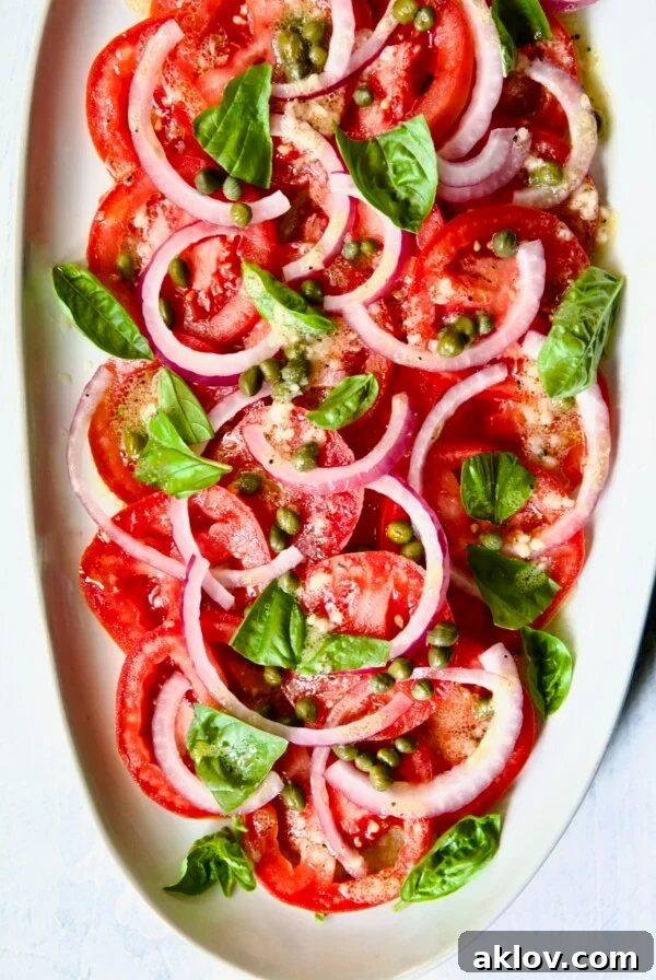 Tomato Onion Salad on white oval platter.