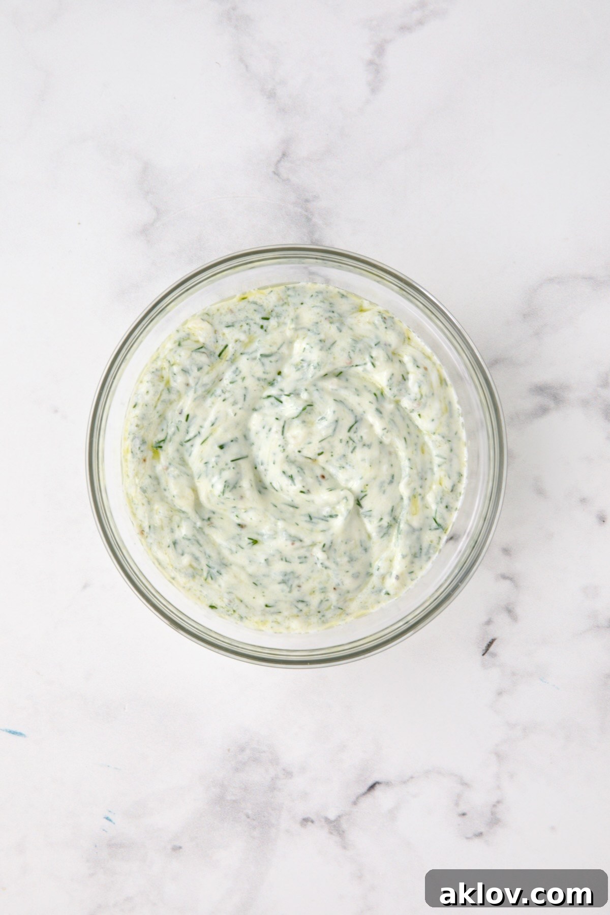 Dill yogurt in glass bowl.