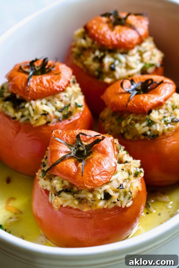 Four Cheesy Rice Stuffed Tomatoes in white baking dish.