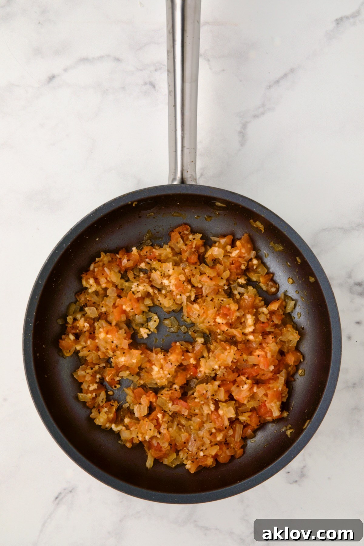 Cooked onions and tomato pulp in a nonstick skillet, gently simmering.