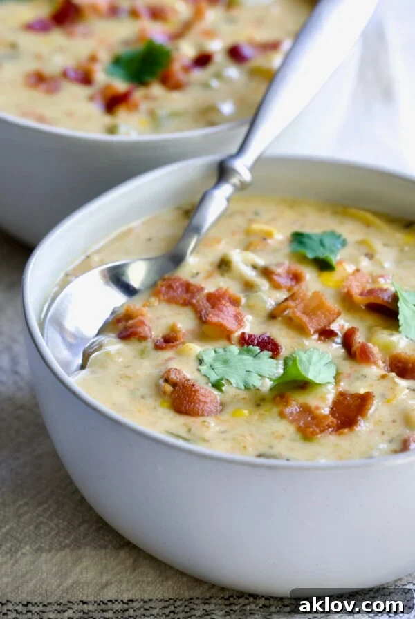 Roasted Poblano Corn Chowder served in a white bowl, elegantly garnished with cilantro sprigs.