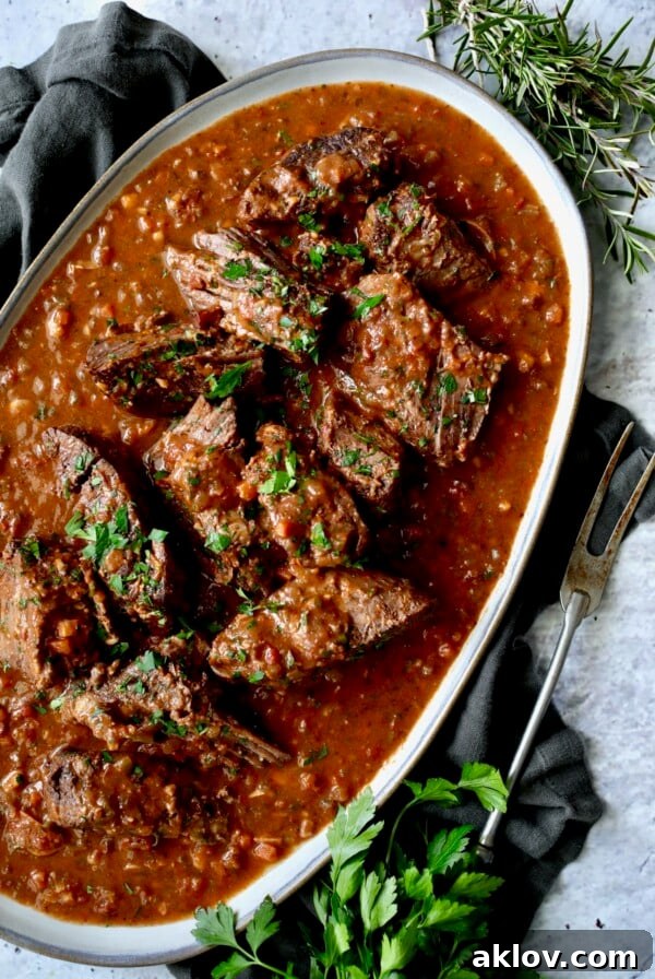 Italian Pot Roast (Stracotto) served on a gray-rimmed platter, showcasing its tender meat and rich sauce.