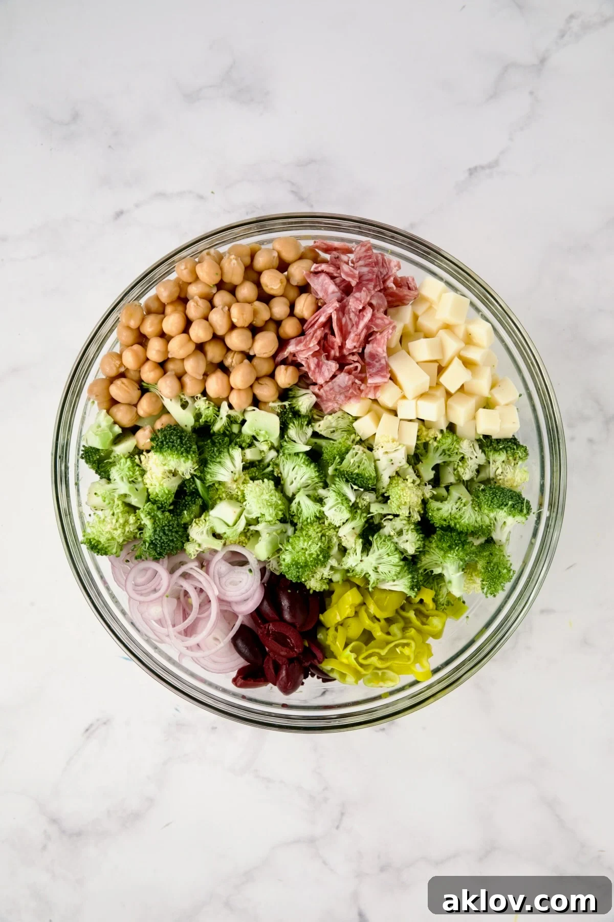 Ingredients for Italian Broccoli Salad in glass bowl before being combined.