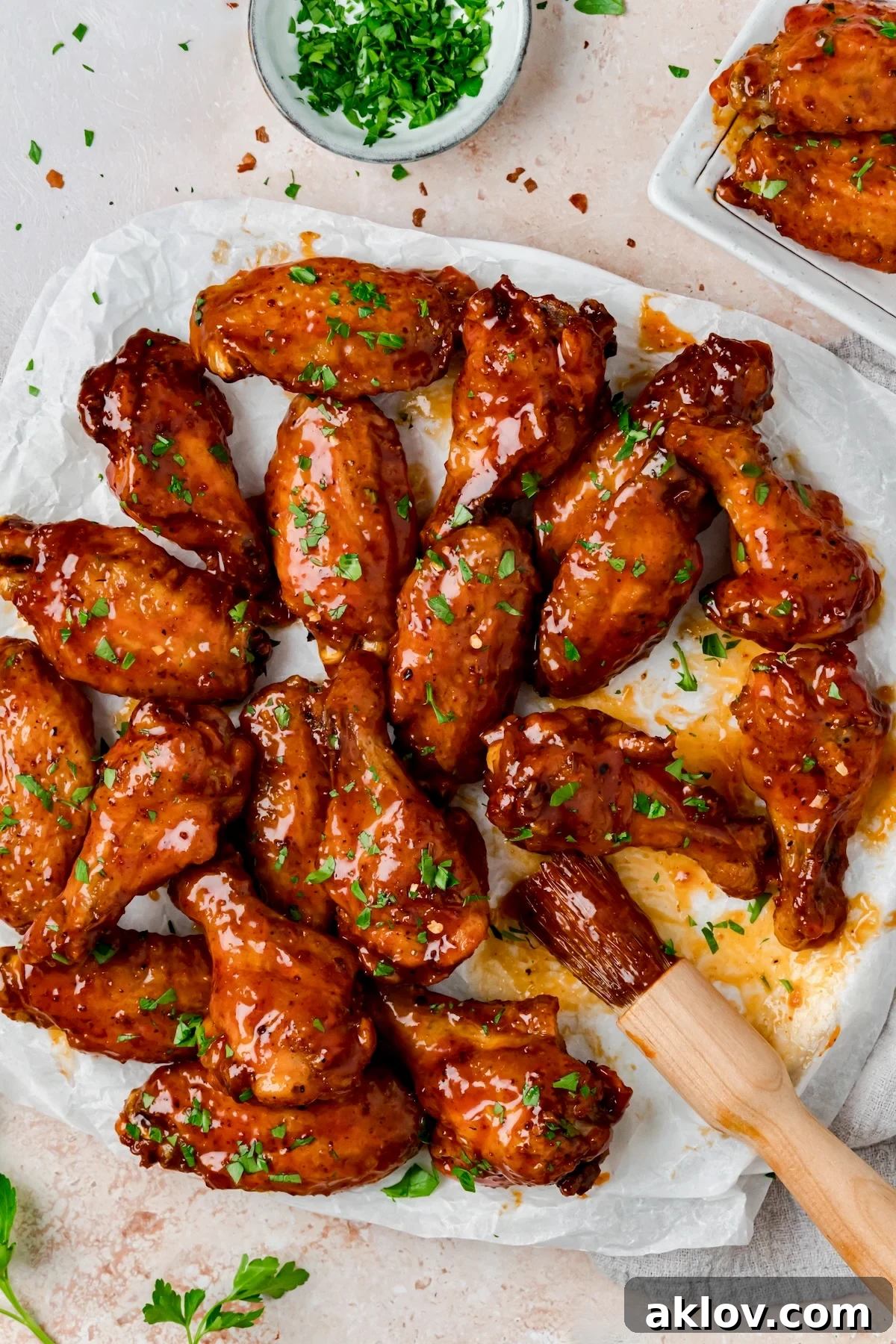 Hot Honey Chicken Wings on parchment paper lined platter with basting brush.