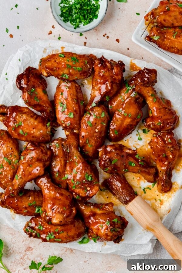 Hot Honey Chicken Wings on parchment paper lined platter with basting brush.