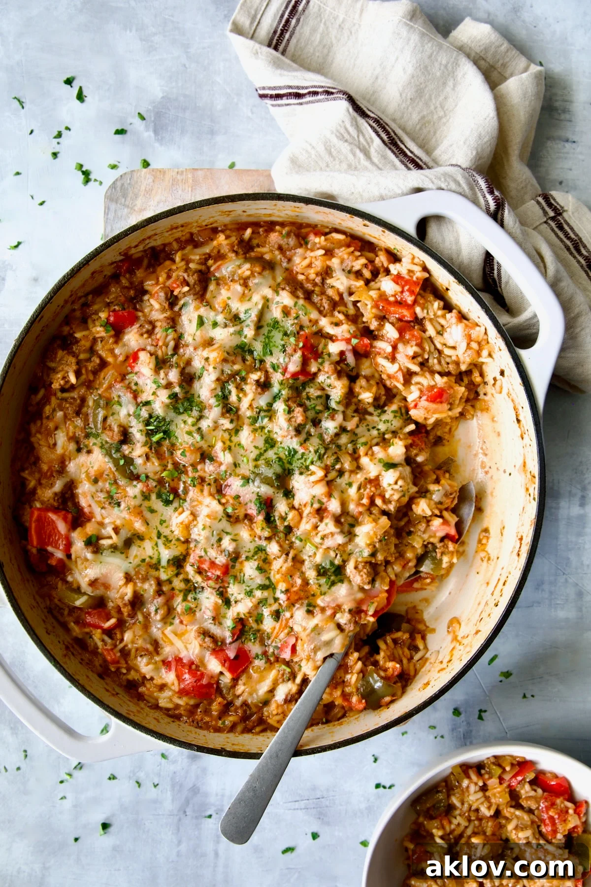 Unstuffed Peppers Skillet served in a white enamel cast iron skillet with a portion dished into a white bowl.