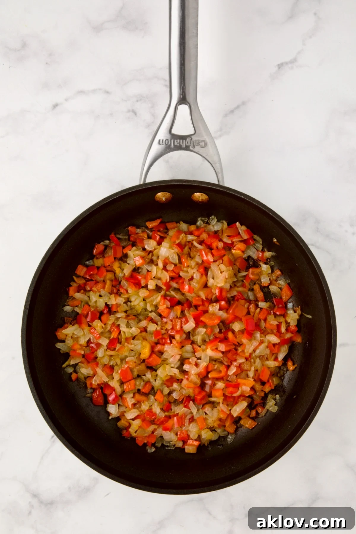Cooked onions and red bell pepper in nonstick skillet.