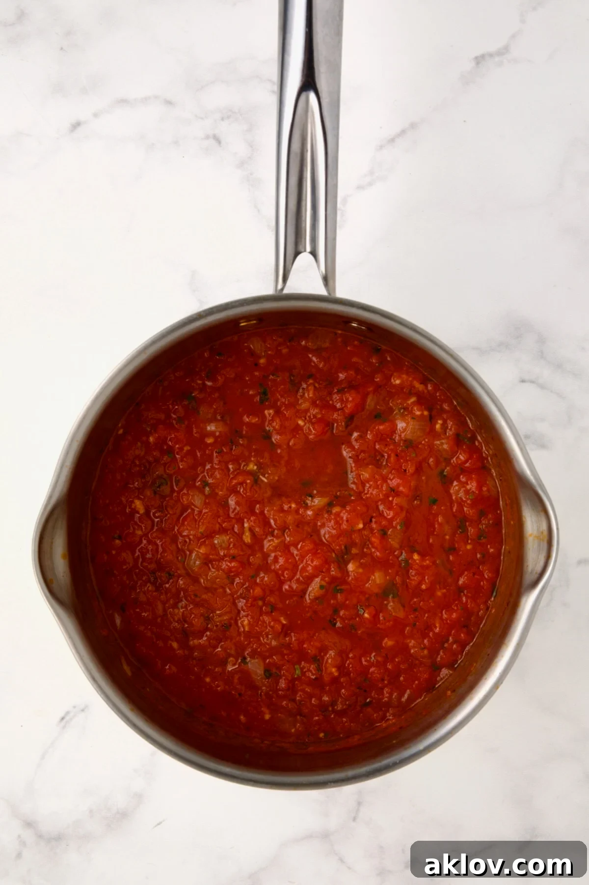 Cooked tomato sauce in stainless steel saucepan.