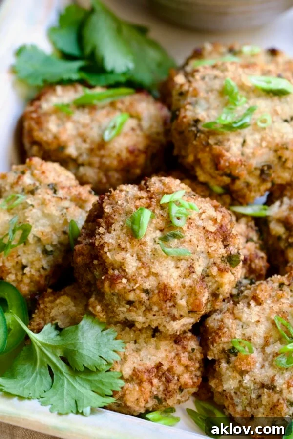 Stacked Thai Green Curry Shrimp Cakes garnished with cilantro leaves.