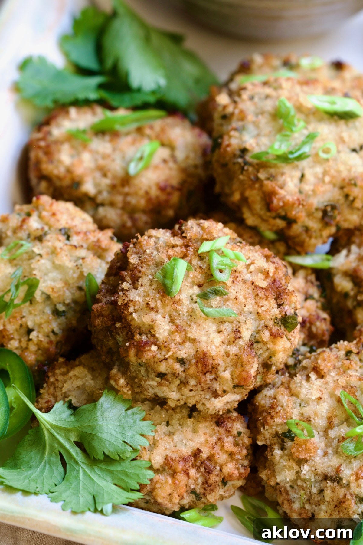 Stacked Thai Green Curry Shrimp Cakes garnished with cilantro leaves.