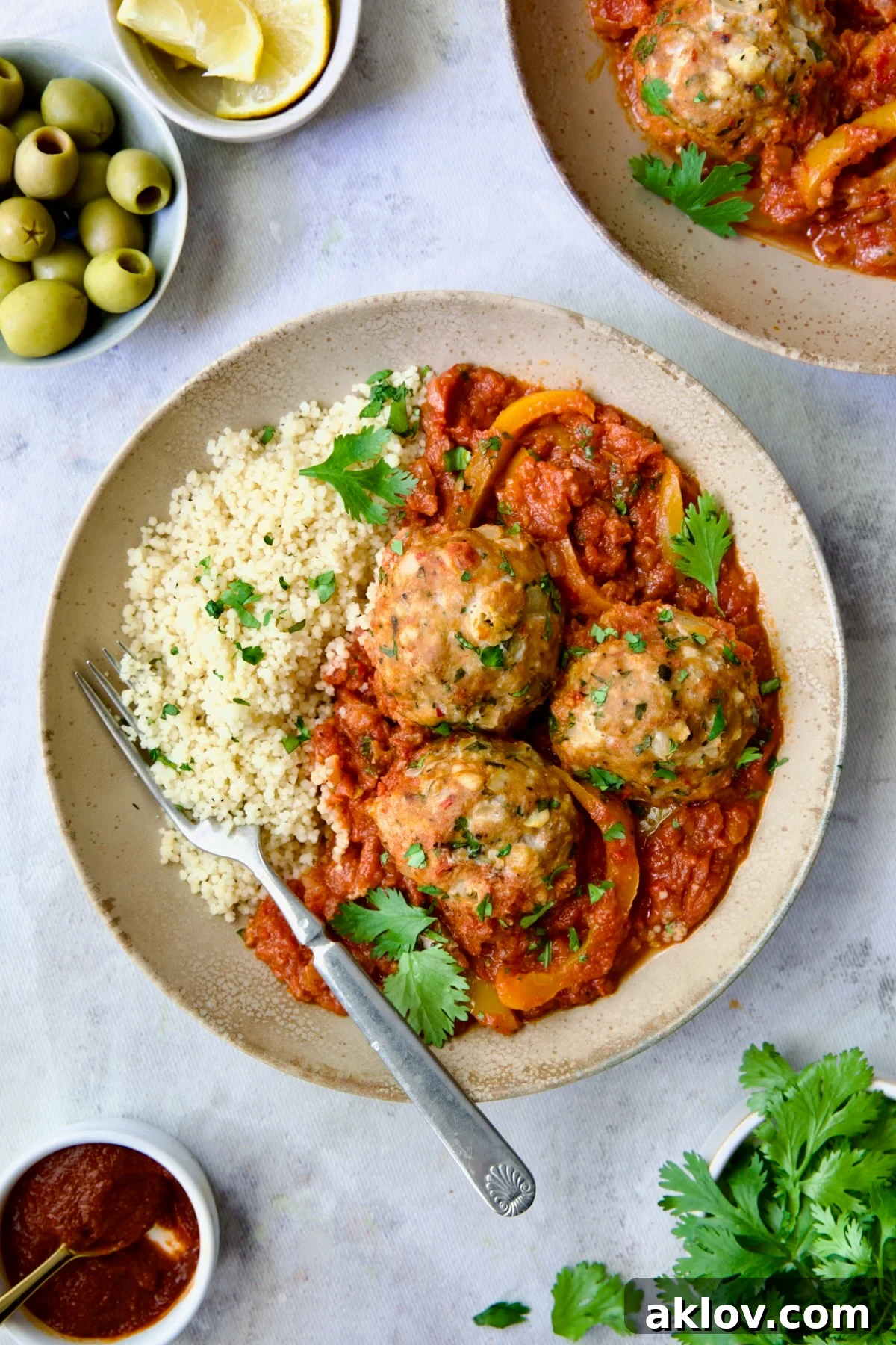 A bowl of delicious Harissa Chicken Meatballs served over fluffy couscous.