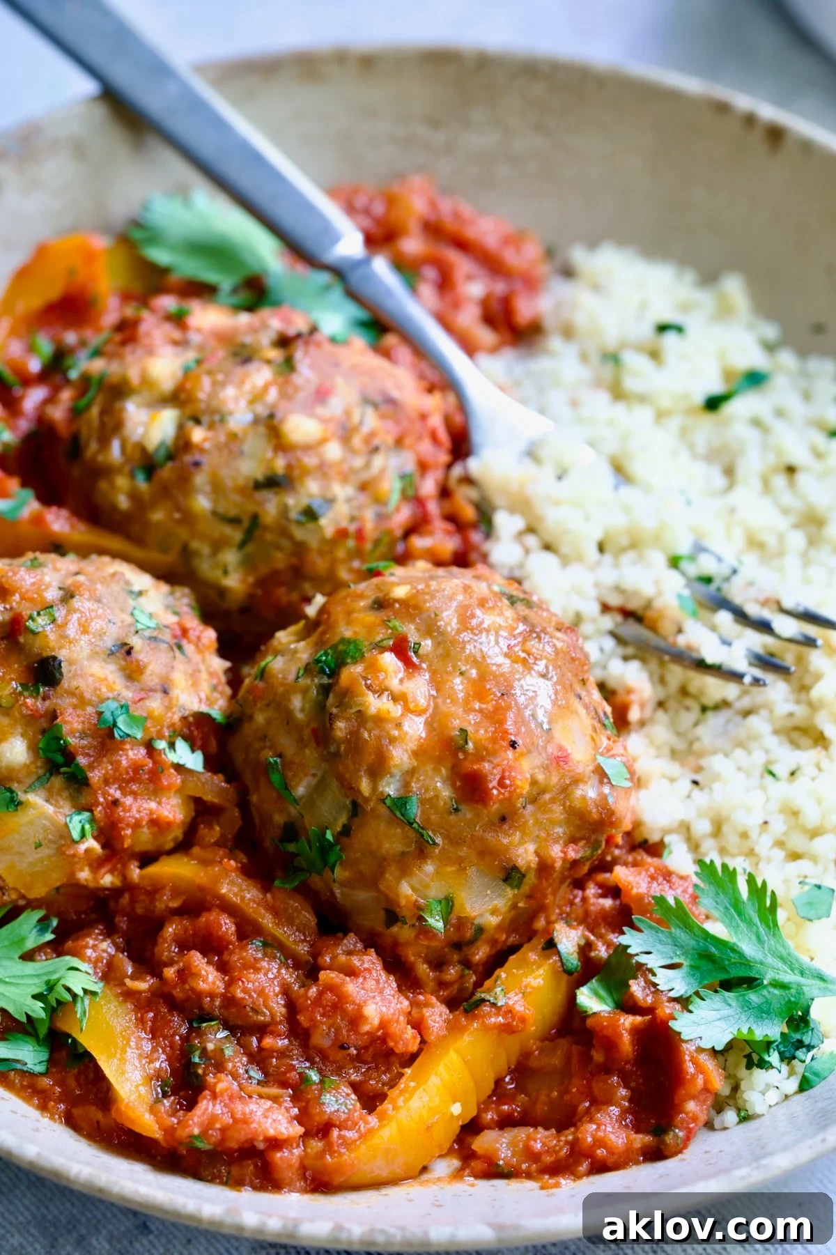Close-up shot of Harissa Chicken Meatballs in a flavorful tomato sauce.