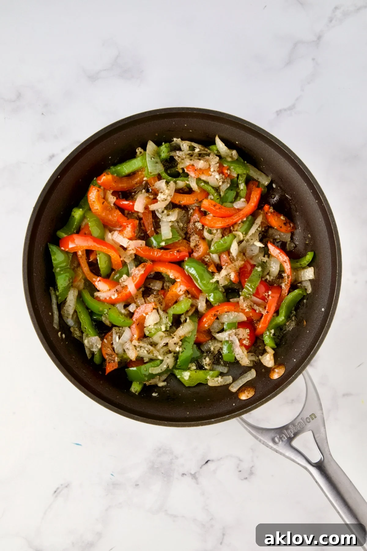 Cooked onions, red bell pepper, and green bell pepper in nonstick skillet.