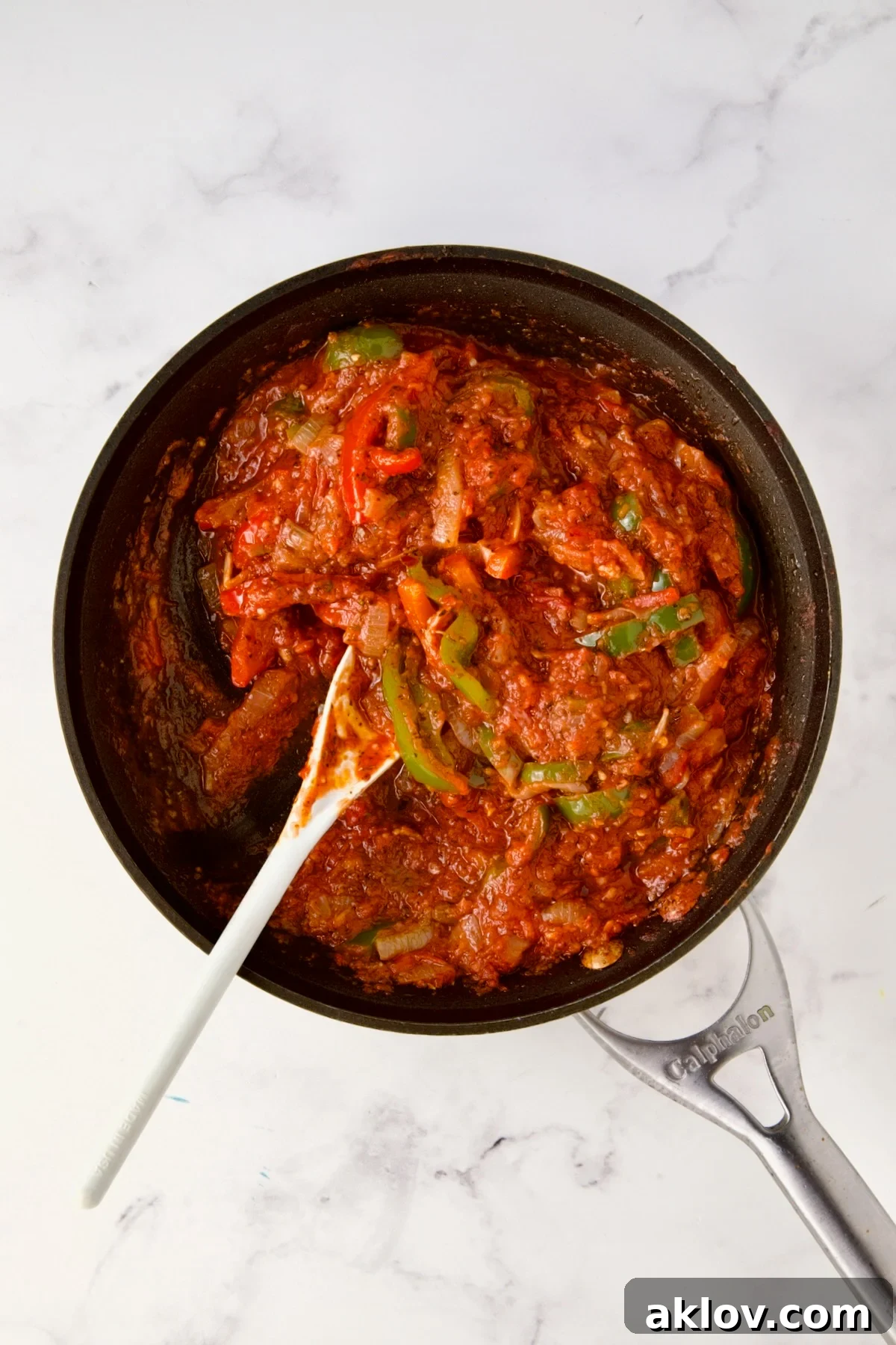 Crushed tomatoes, onions, and bell peppers in nonstick skillet.