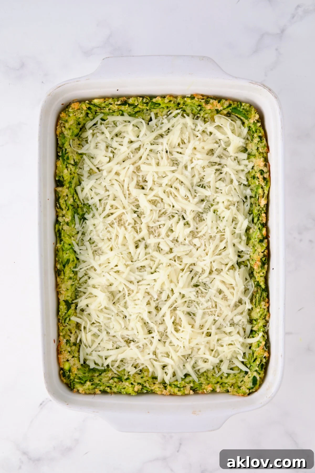 Layer of cheese over zucchini crust.