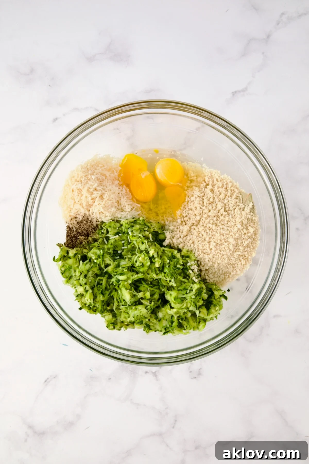 Ingredients for the zucchini crust in glass bowl before being mixed together.