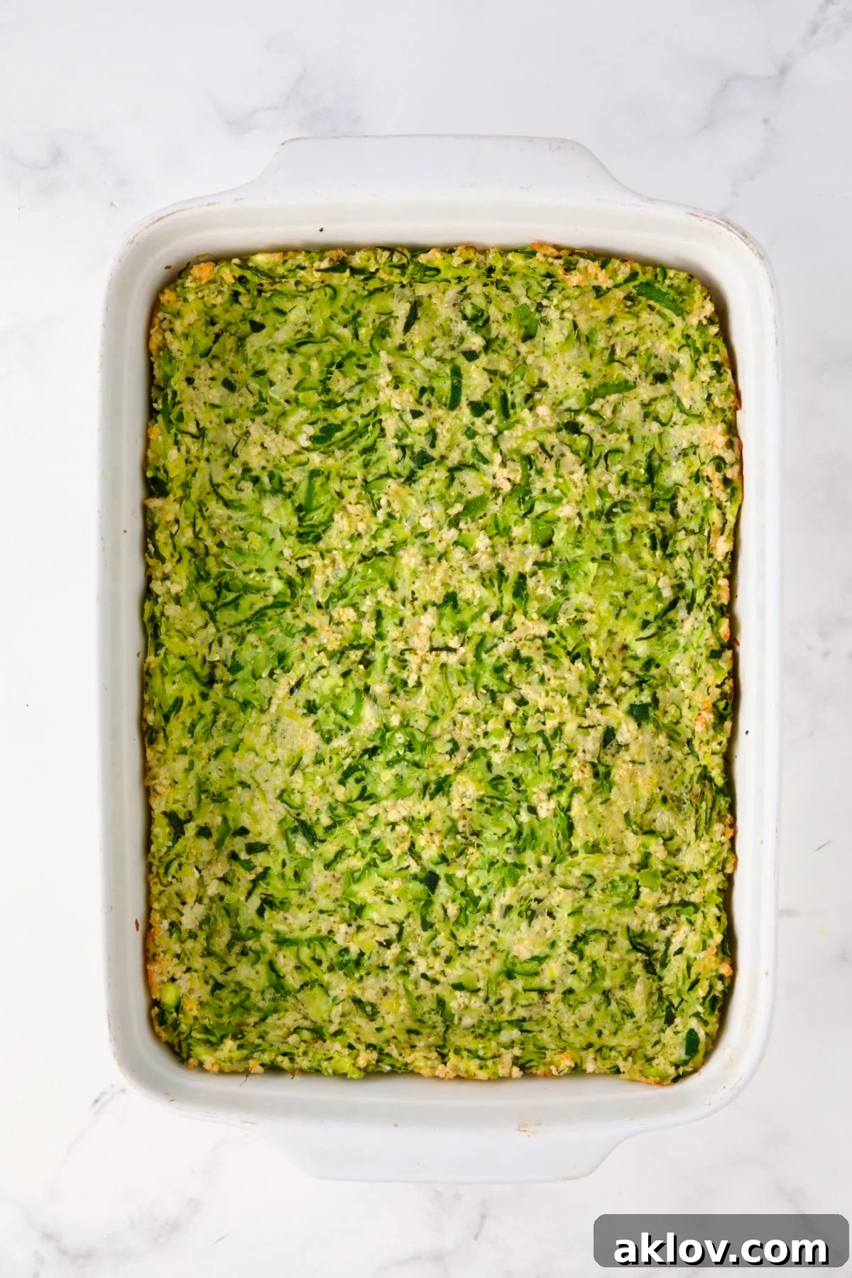 Zucchini crust in white rectangular baking dish after being baked.