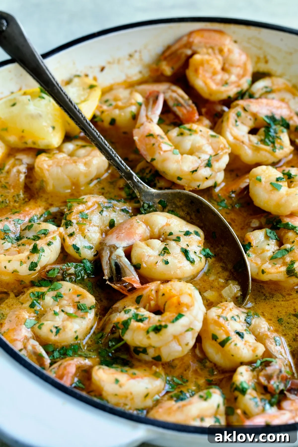 Cajun Butter Shrimp with spoon picking up a shrimp.