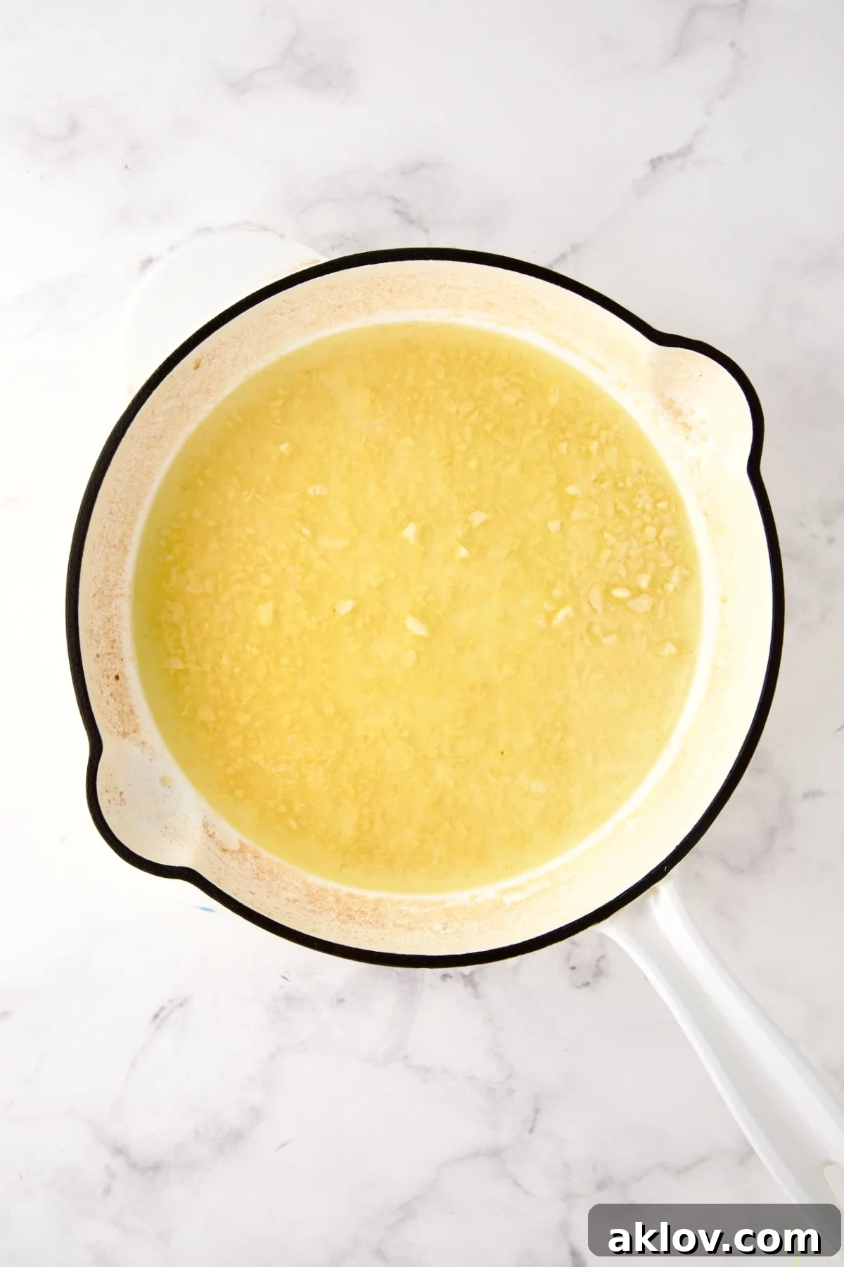 White wine and lemon juice added to garlic in skillet.