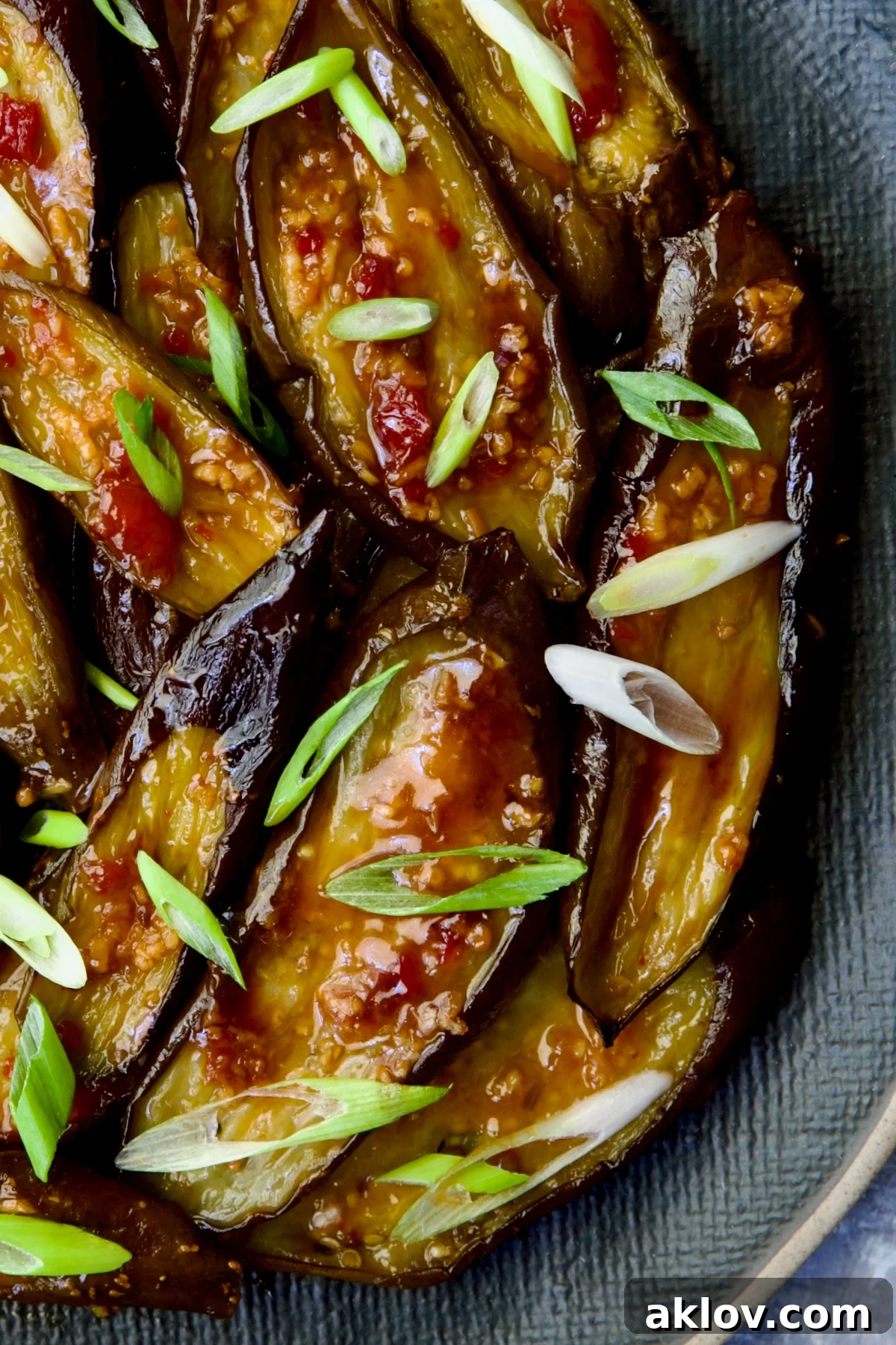 Thai Sweet Chili Glazed Eggplant Recipe 9 Thai Sweet Chili Eggplant on blue oval plate garnished with scallions.