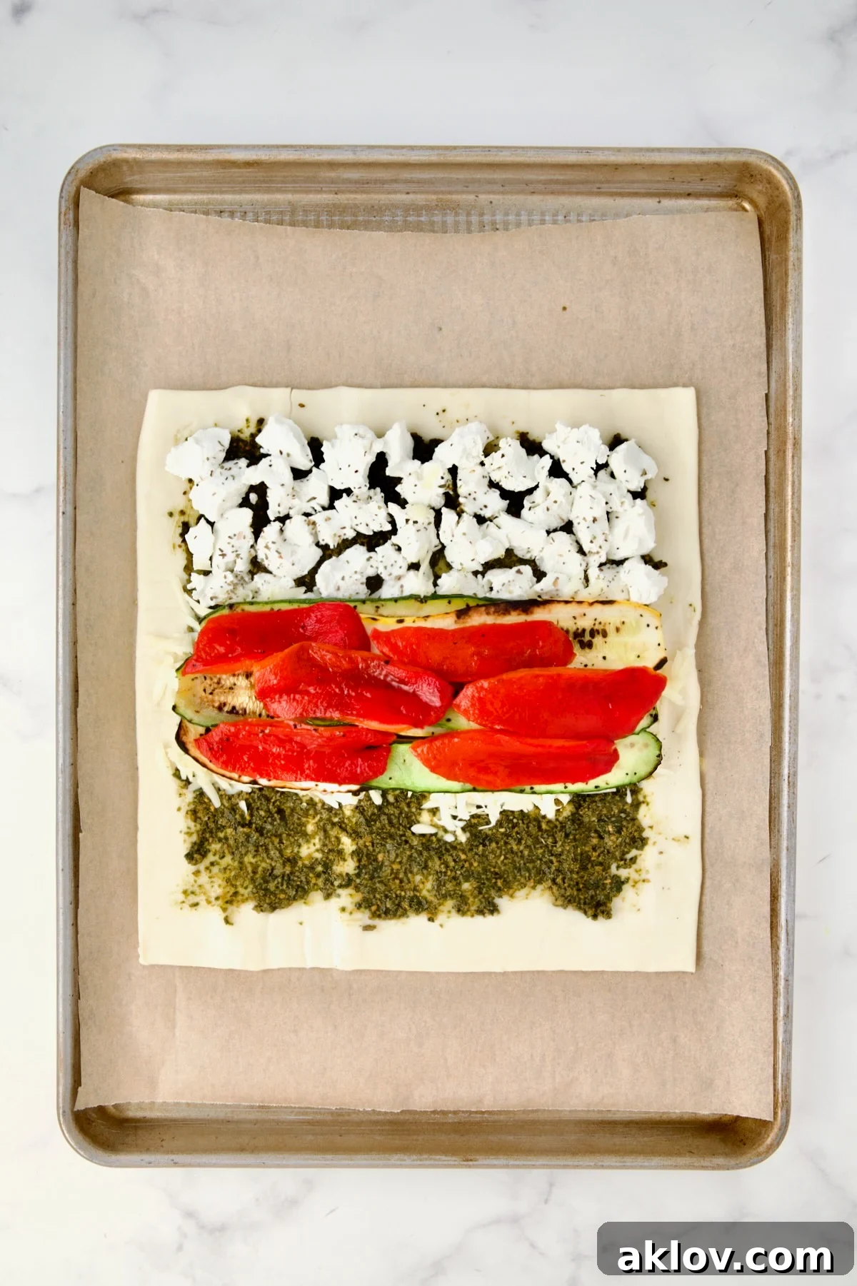 First layer of zucchini and yellow squash along with the red bell pepper placed over the shallot and cheese.