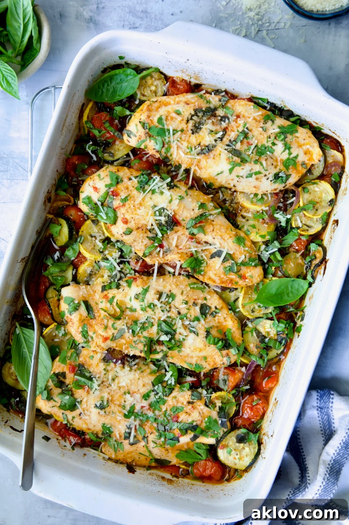 One-Pan Summer Vegetable and Chicken Bake in white rectangular baking dish.