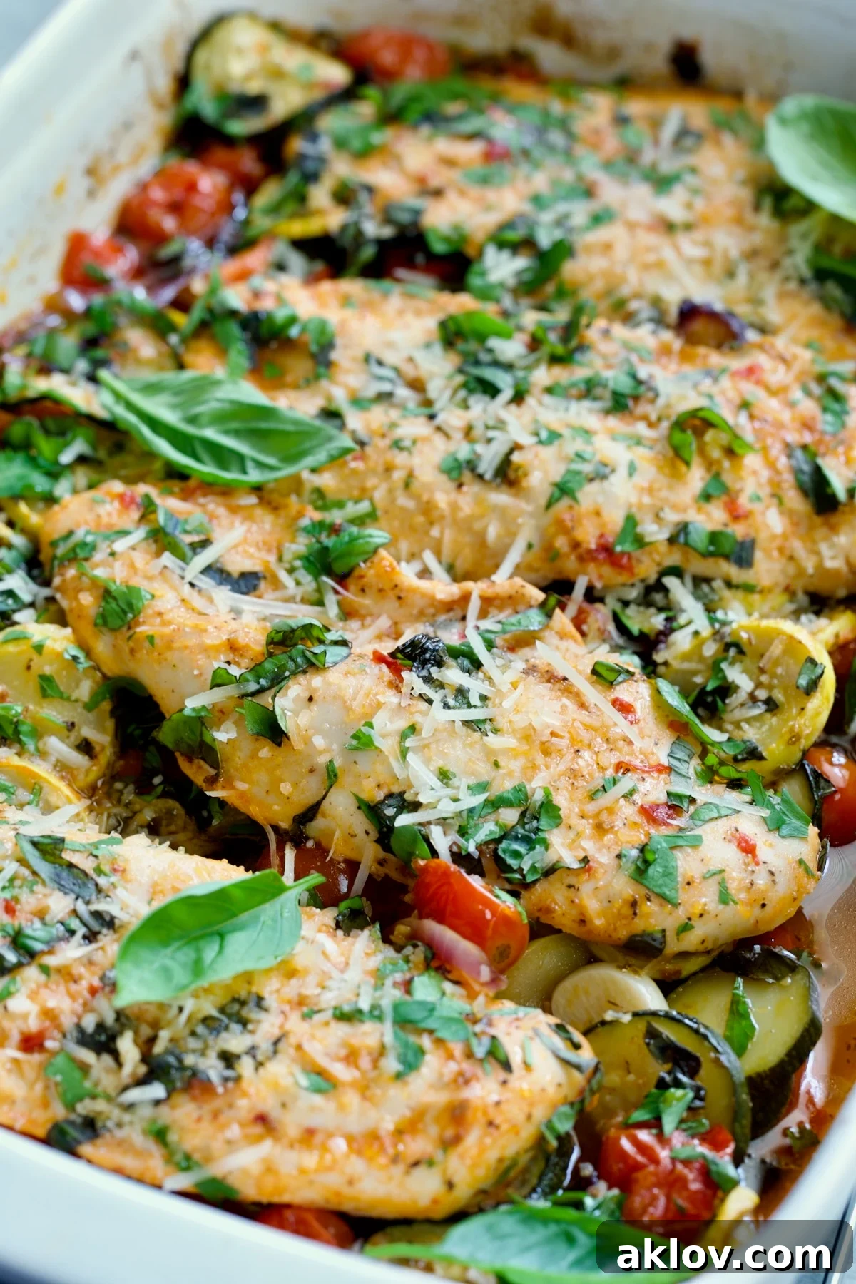 One-Pan Summer Vegetable and Chicken Bake in white rectangular baking dish.