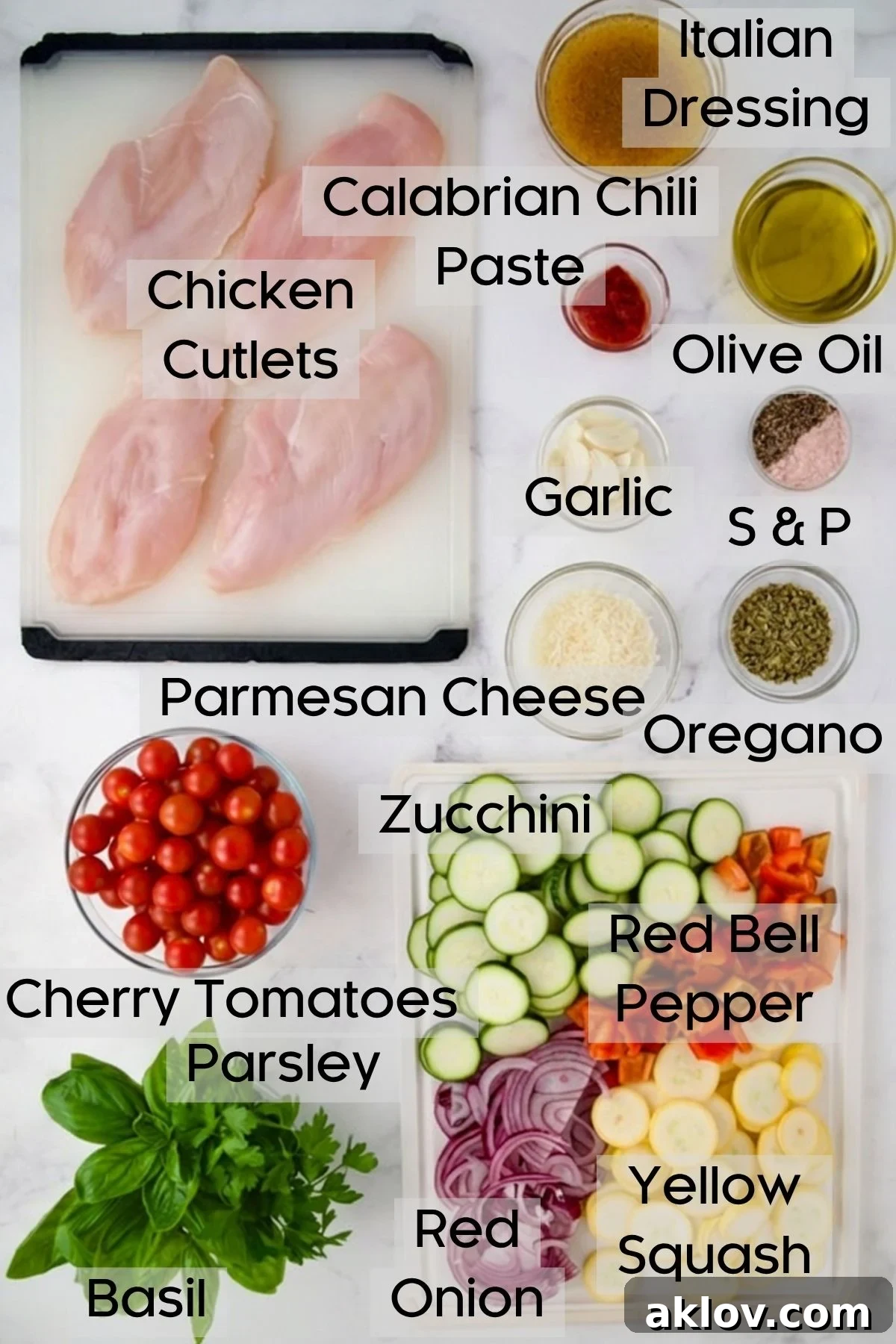 Ingredients for One-Pan Summer Vegetable and Chicken Bake on white plastic cutting boards and in glass bowls.