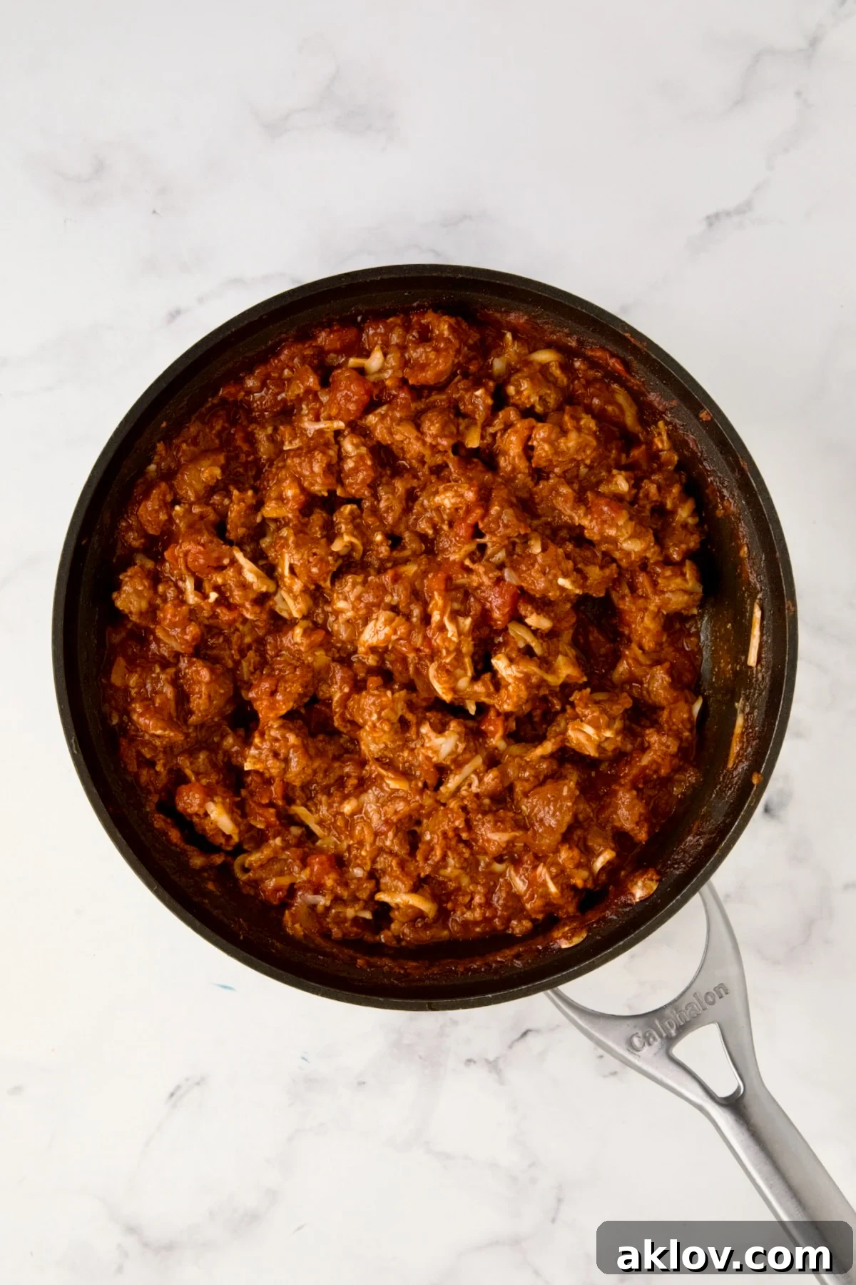 Cooked chorizo filling in nonstick skillet with half the cheese added.