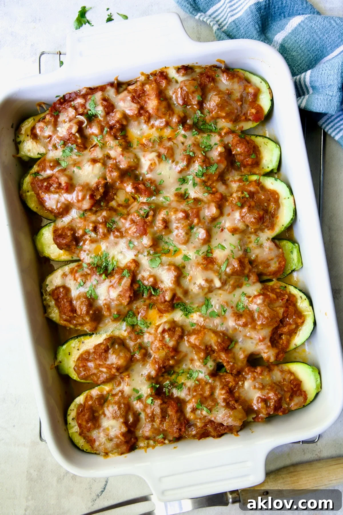 Six baked Chorizo-Stuffed Zucchini in white rectangular baking dish.
