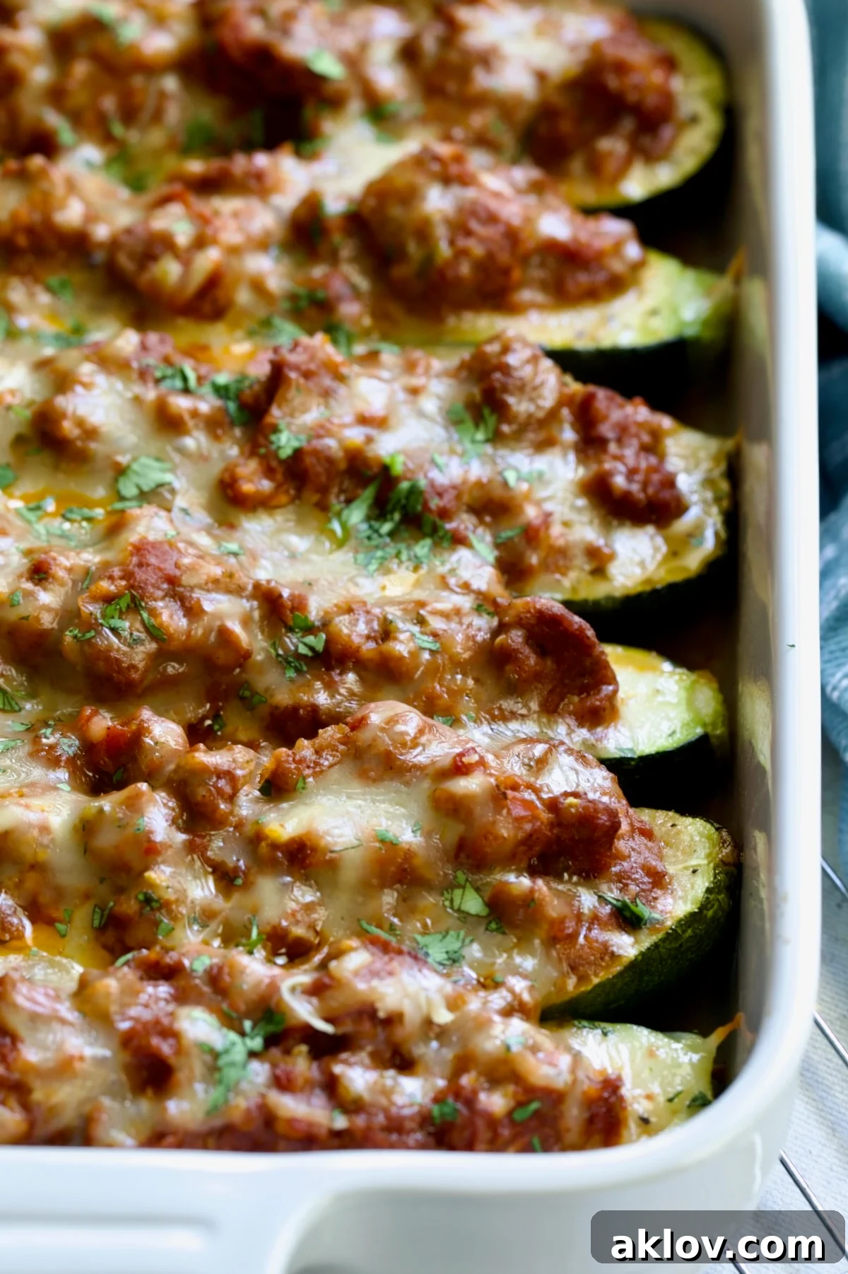 Six baked Chorizo-Stuffed Zucchini in white rectangular baking dish.