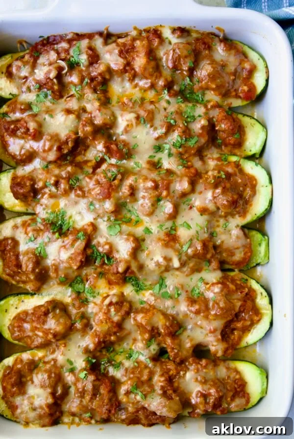 Six baked Chorizo-Stuffed Zucchini in white rectangular baking dish.