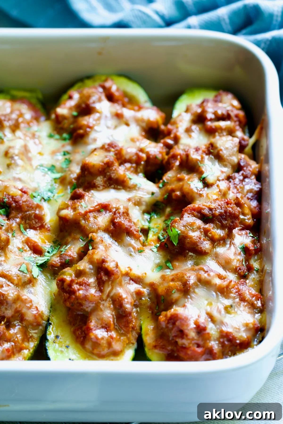 Close-up of two Chorizo-Stuffed Zucchini in white rectangular baking dish.