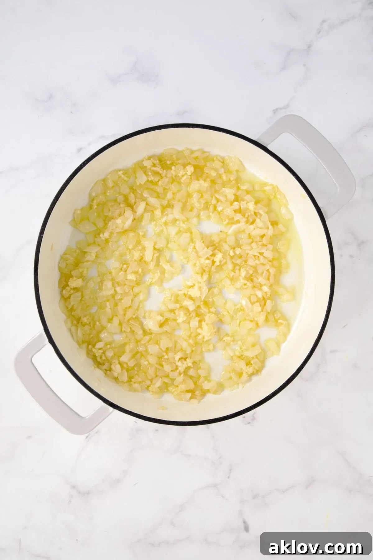 Cooked onions in white enamel cast iron skillet.