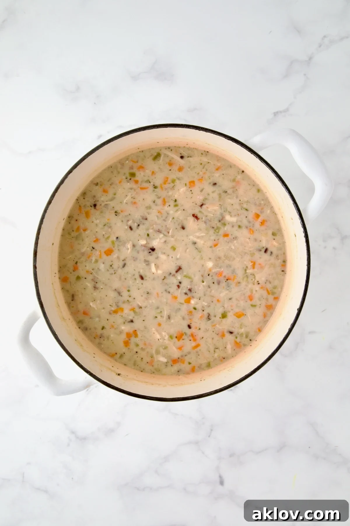Finished Chicken and Wild Rice Soup in white enamel Dutch oven.